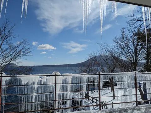 Lake Shikotsu in winter from the rest area at Marukoma Onsen, icicles hanging from the eaves (February 8, 2025)